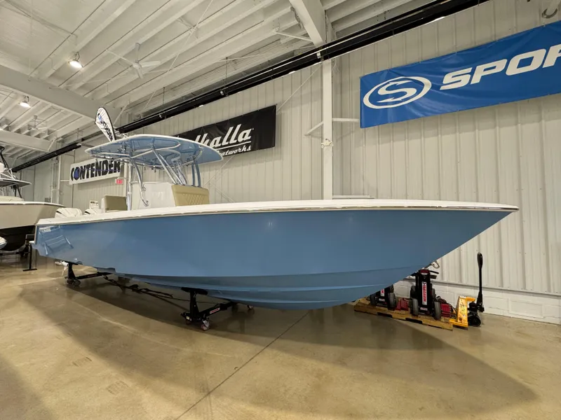 Slide: The Image of 2025 Contender 32 ST boat in showroom, blue hull, indoor display. - 2