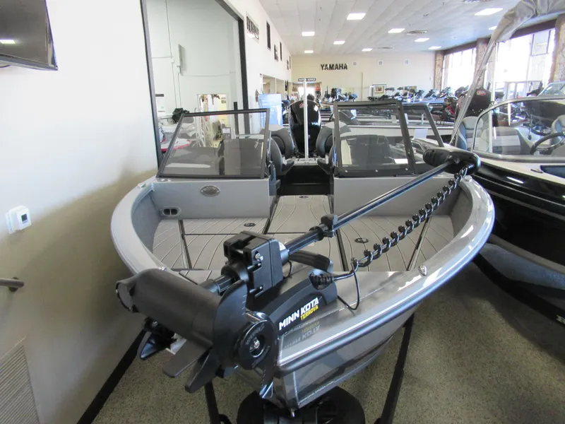 Slide: The Image of 2024 Vexus ADX 190 boat on display in showroom with Minn Kota trolling motor. - 1