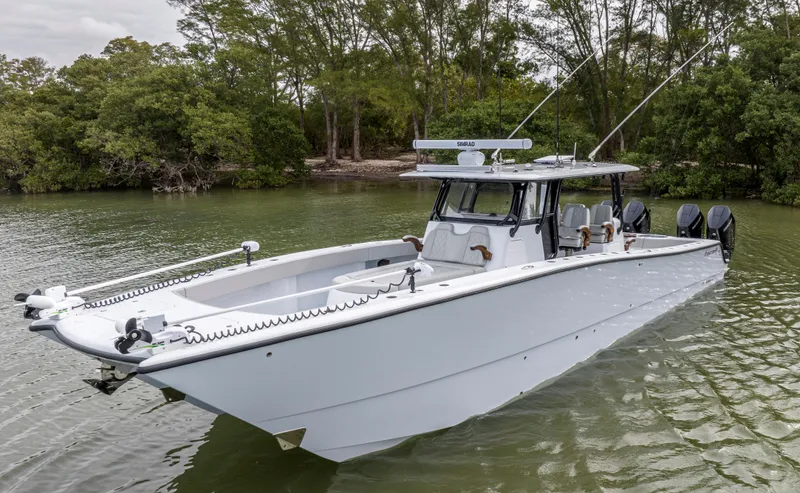 Slide: The Image of 2024 Freeman 42 LR boat on calm water near lush greenery. - 10