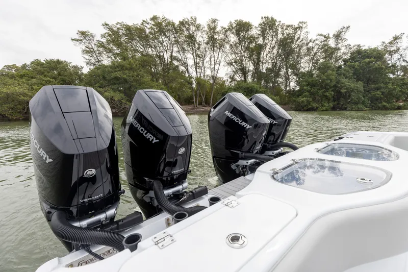 Slide: The Image of Freeman 42 LR 2024 boat with four Mercury outboard engines on a lake. - 12