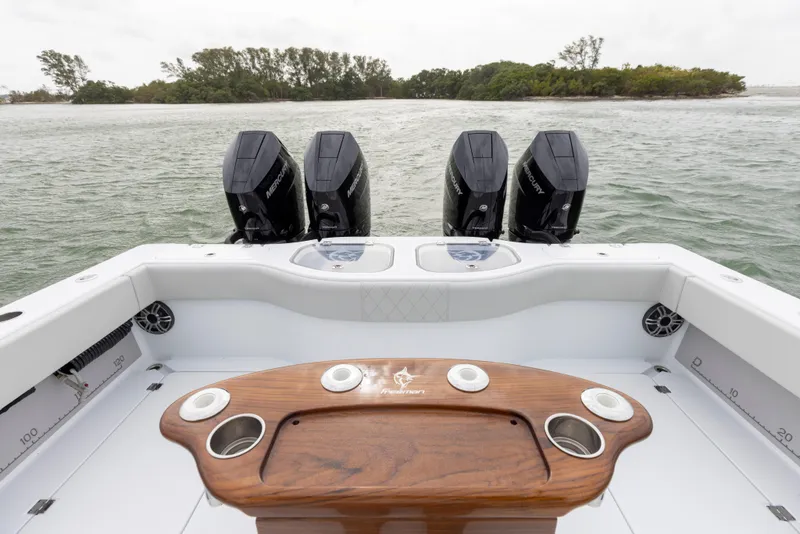 Slide: The Image of 2024 Freeman 42 LR boat with four outboard motors and a wooden fishing station. - 18