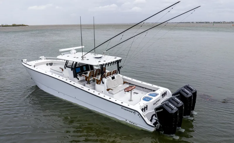 Slide: The Image of 2024 Freeman 42 LR boat with multiple outboard engines on calm water. - 2