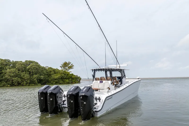 Slide: The Image of 2024 Freeman 42 LR boat with four outboard engines in calm waters. - 4