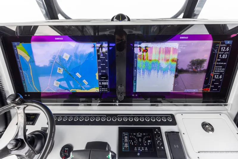 Slide: The Image of Freeman 42 LR 2024 boat dashboard with dual navigation screens and steering wheel. - 46