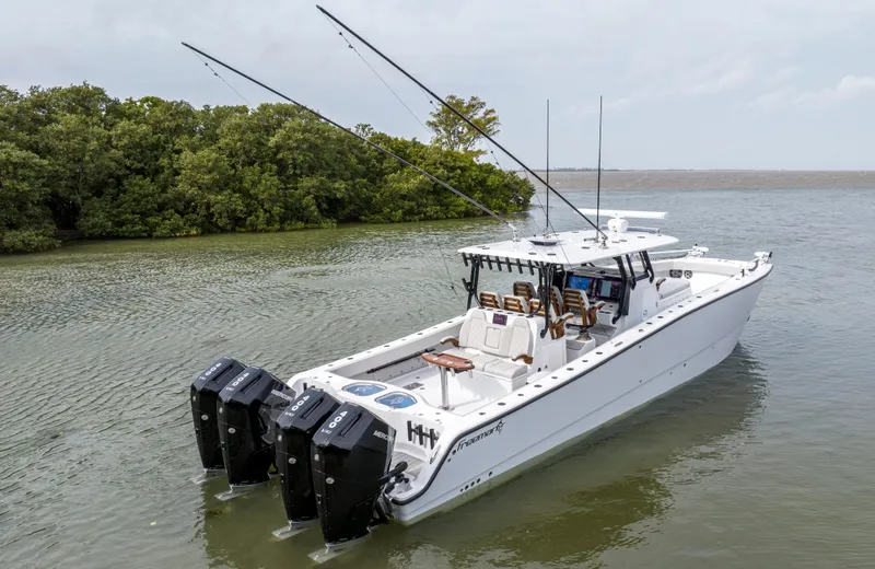 Slide: The Image of 2024 Freeman 42 LR boat with multiple outboard engines on calm water. - 5