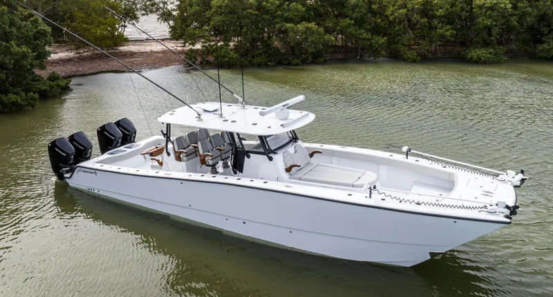 Slide: The Image of 2024 Freeman 42 LR boat in calm waters near a forested shoreline. - 8