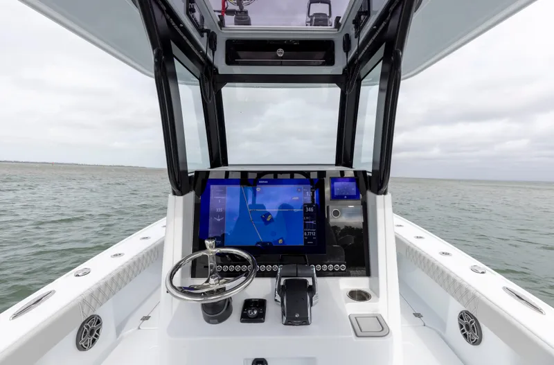 Slide: The Image of 2024 Freeman 28 boat cockpit with advanced navigation system on open water. - 23