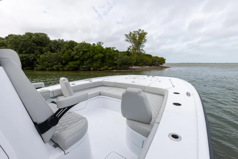 Slide: The Image of 2024 Freeman 28 boat with seating, near lush green shoreline. - 24