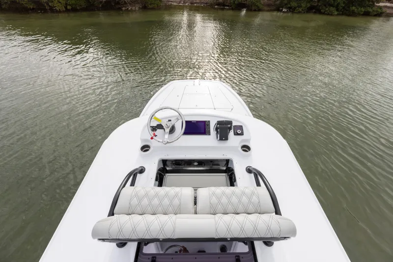 Slide: The Image of 2024 Freeman 28 boat interior with steering wheel and cushioned seats on calm water. - 31