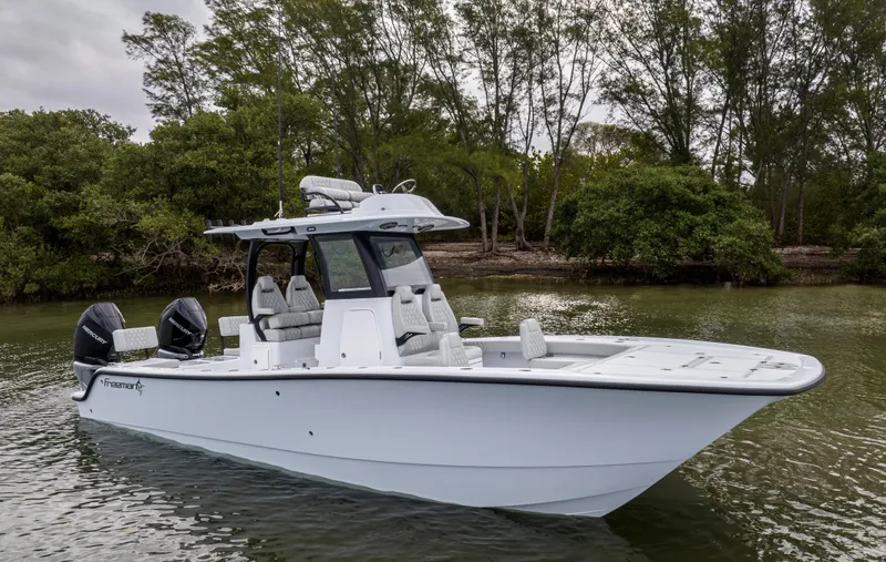 Slide: The Image of 2024 Freeman 28 boat on calm water near a forested shoreline. - 9