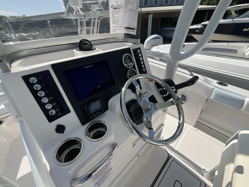 Slide: The Image of 2024 Robalo 222 Explore boat dashboard with steering wheel and control panel. - 12