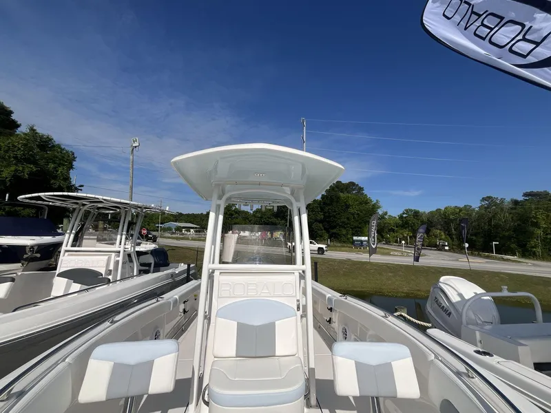 Slide: The Image of 2024 Robalo 222 Explore boat on display under clear blue sky. - 13