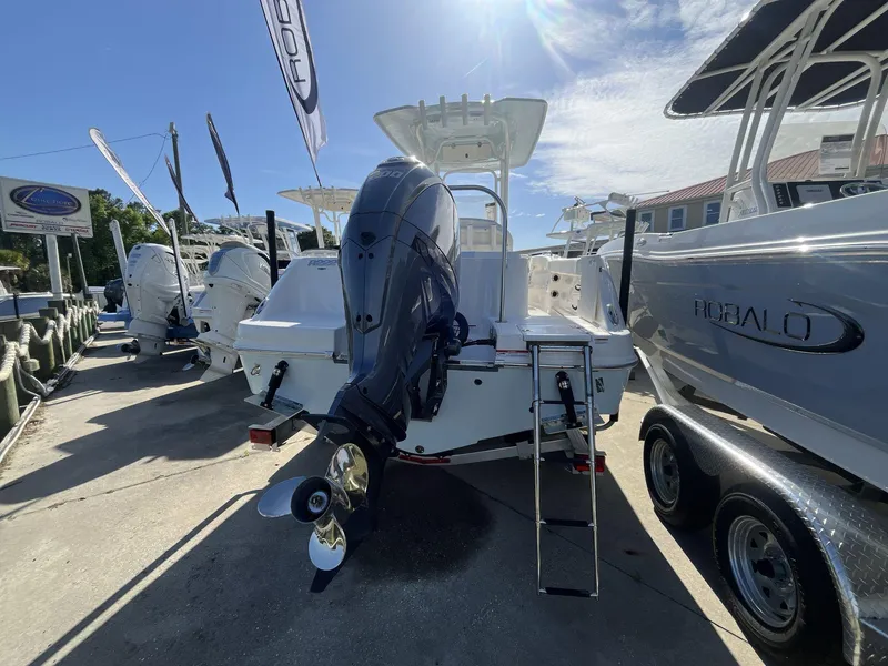 Slide: The Image of 2024 Robalo 222 Explore boat with outboard motor, displayed at a dealership. - 4