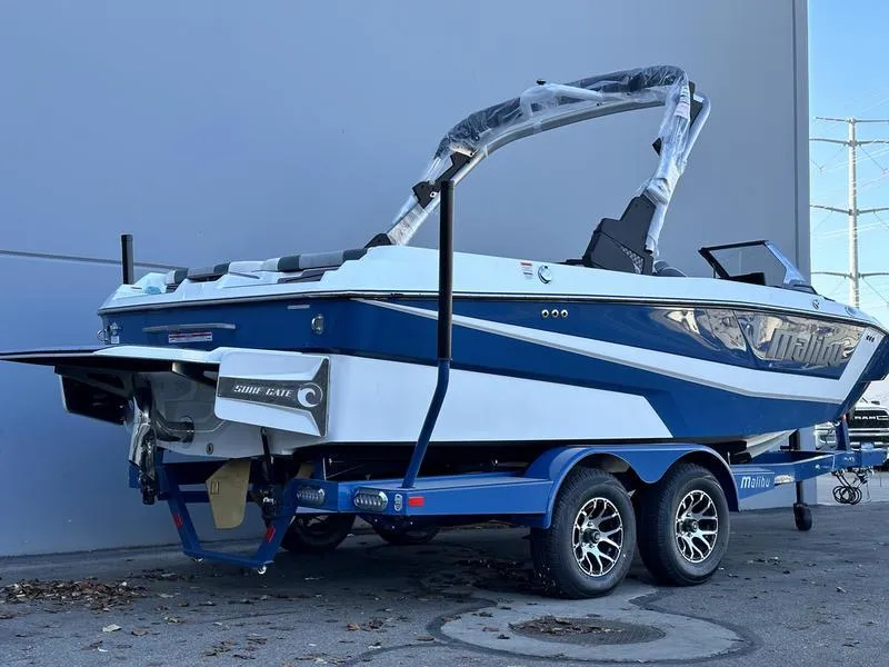 Slide: The Image of 2024 Malibu 21 LX-R boat on a blue trailer, parked outdoors. - 10