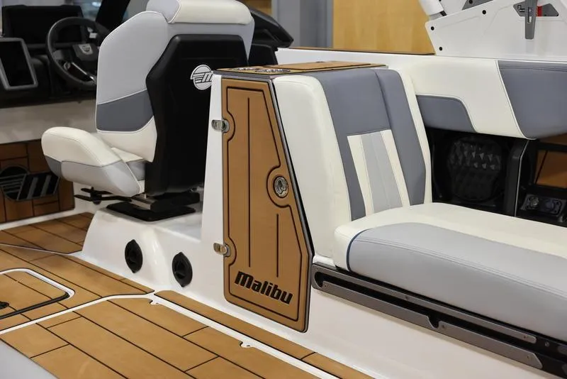 Slide: The Image of 2024 Malibu 24 MXZ boat interior with white and gray seating and wood accents. - 17