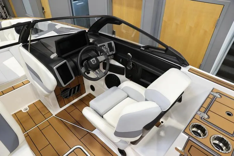 Slide: The Image of 2024 Malibu 24 MXZ boat interior with modern dashboard and white seating. - 4