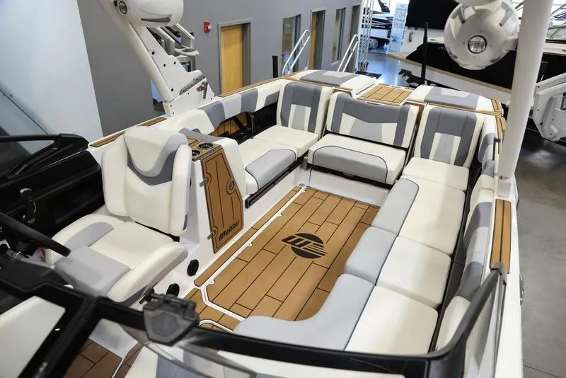Slide: The Image of 2024 Malibu 24 MXZ boat interior with spacious seating and teak flooring. - 7
