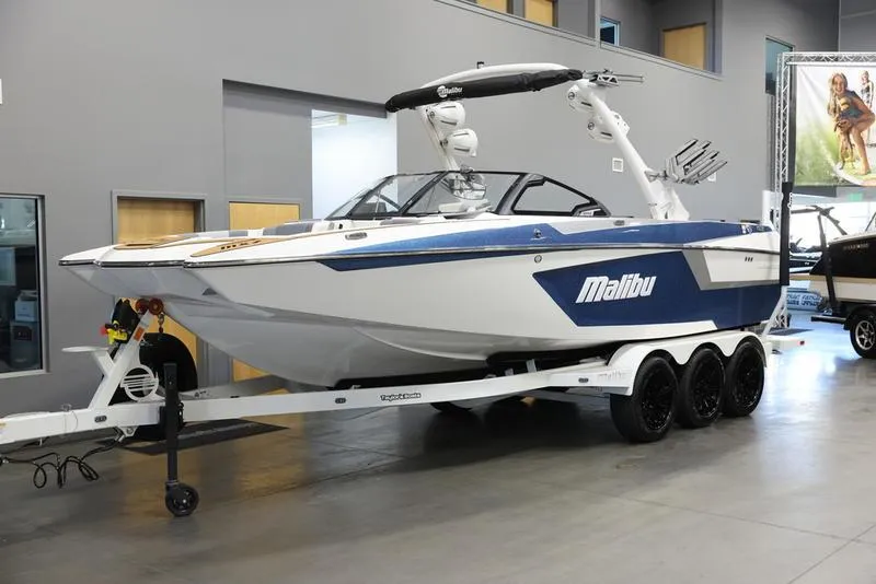 Slide: The Image of 2024 Malibu 24 MXZ boat on a trailer in a showroom. - 8
