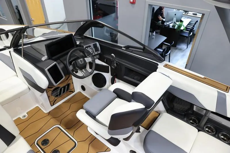 Slide: The Image of 2024 Malibu 23 MXZ boat interior with modern dashboard and seating. - 11