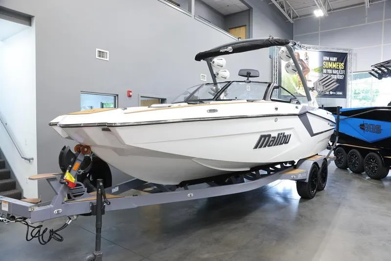 Slide: The Image of 2024 Malibu 23 MXZ boat on trailer in showroom. - 25