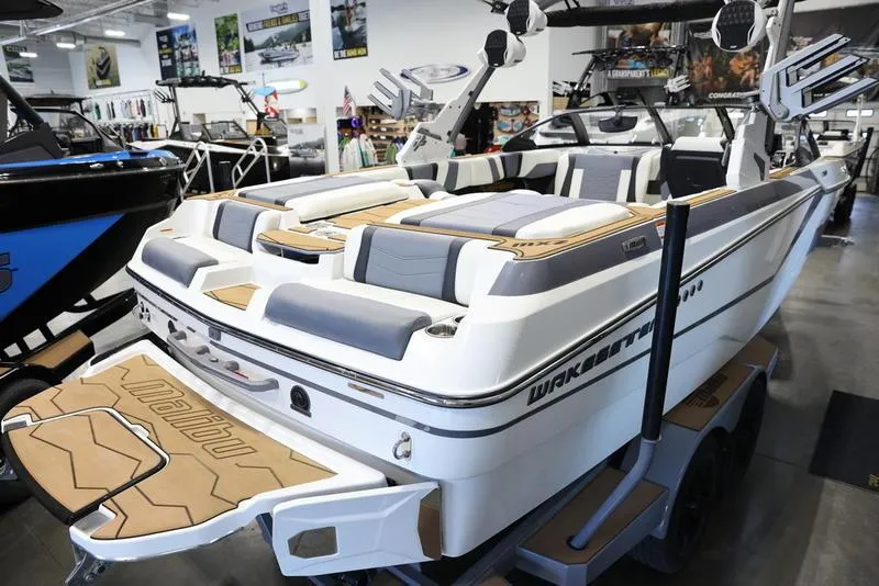 Slide: The Image of 2024 Malibu 23 MXZ wakeboard boat in showroom, rear view. - 26