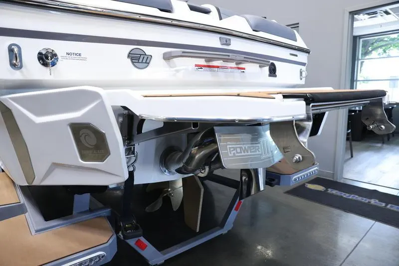 Slide: The Image of 2024 Malibu 23 MXZ boat rear view showcasing engine and propeller. - 4