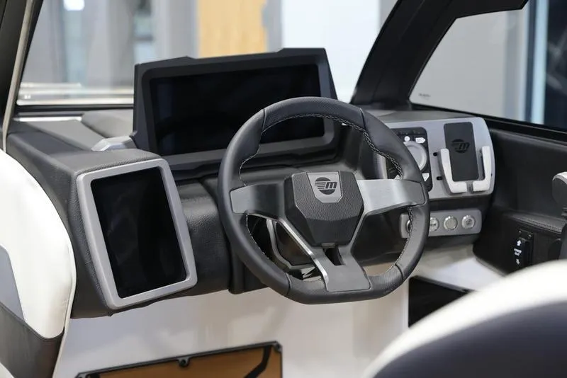 Slide: The Image of 2024 Malibu 23 MXZ boat dashboard with steering wheel and digital display. - 9