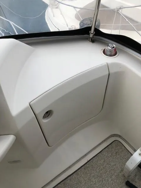 Slide: The Image of 2004 Silverton 34C boat interior detail with storage compartment and drink holder. - 16