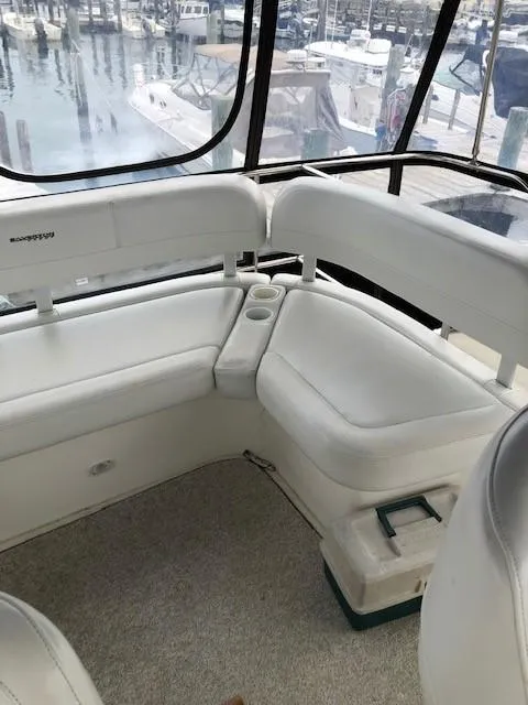 Slide: The Image of 2004 Silverton 34C boat interior with white seating and marina view. - 17