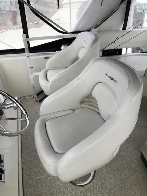 Slide: The Image of 2004 Silverton 34C boat interior with two white captain chairs. - 20