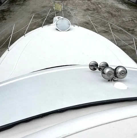 Slide: The Image of 2004 Silverton 34C yacht bow with railing and horn, docked on calm water. - 42