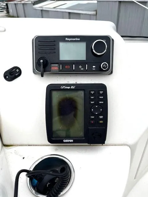 Slide: The Image of 2004 Silverton 34C boat dashboard with Raymarine and Garmin navigation systems. - 44