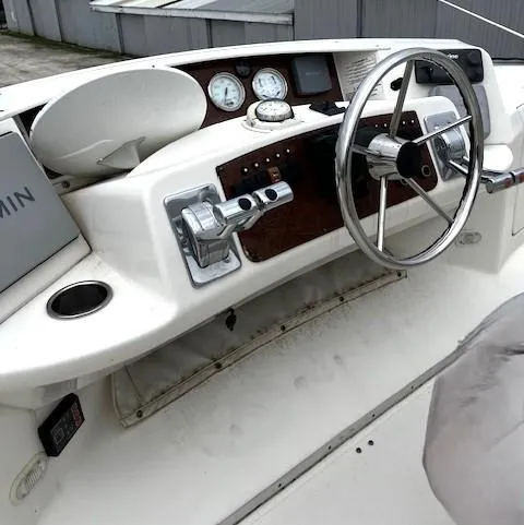 Slide: The Image of 2004 Silverton 34C boat helm with steering wheel, gauges, and controls. - 46