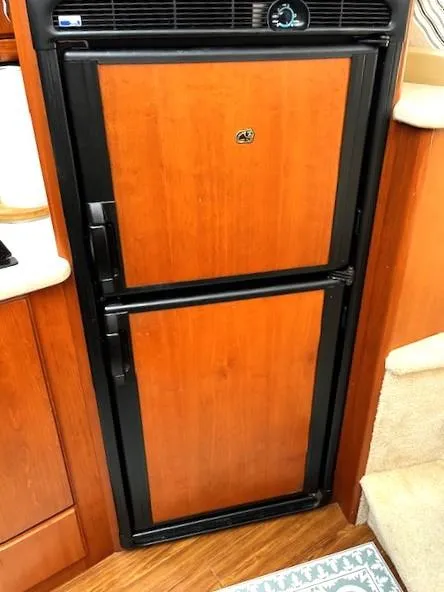 Slide: The Image of Wood-paneled refrigerator in 2004 Silverton 34C yacht interior. - 48