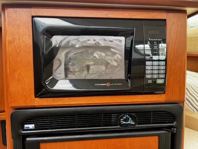 Slide: The Image of Microwave oven in 2004 Silverton 34C boat interior, featuring wood cabinetry. - 49