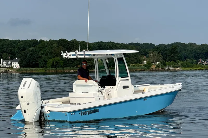 Slide: The Image of 2024 Everglades 253 Center Console boat on calm water with a person at the helm. - 7