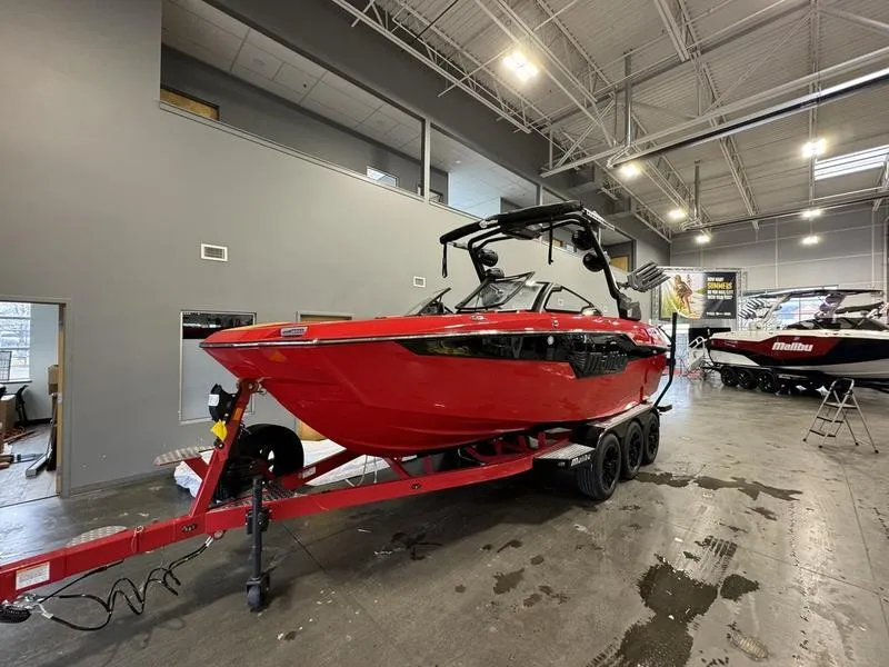 Slide: The Image of 2024 Malibu M220 red boat on trailer in showroom. - 3