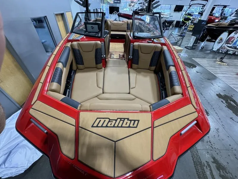 Slide: The Image of 2024 Malibu M220 boat interior with red and tan seating, showcased indoors. - 4
