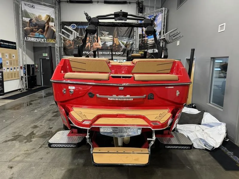 Slide: The Image of 2024 Malibu M220 boat, red exterior, displayed indoors with tan seating. - 5