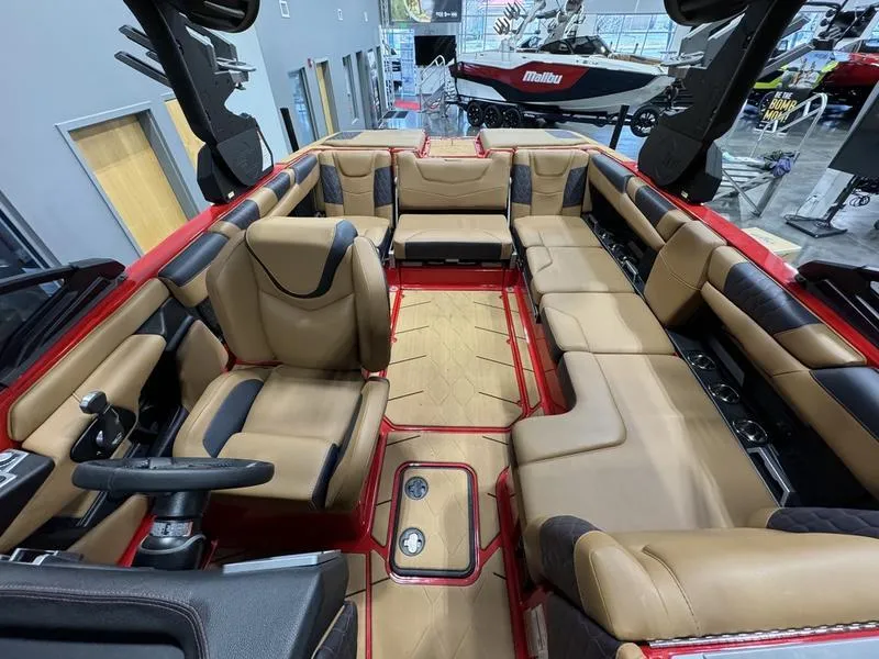 Slide: The Image of 2024 Malibu M220 boat interior with luxurious tan and black seating. - 6