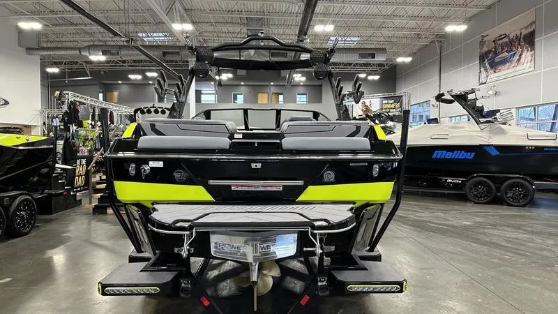 Slide: The Image of 2024 Malibu 22 LSV boat displayed in a showroom, rear view. - 6