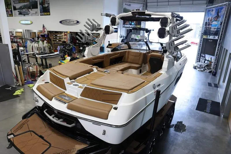 Slide: The Image of 2024 Malibu M220 boat with tan interior in showroom. - 10