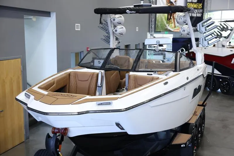Slide: The Image of 2024 Malibu M220 boat with tan interior on display in showroom. - 11