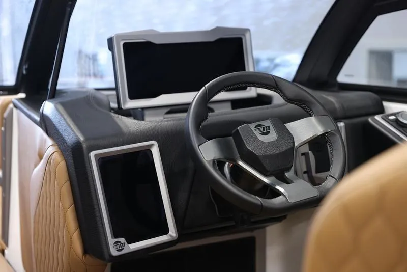 Slide: The Image of 2024 Malibu M220 boat dashboard with modern steering wheel and digital displays. - 14