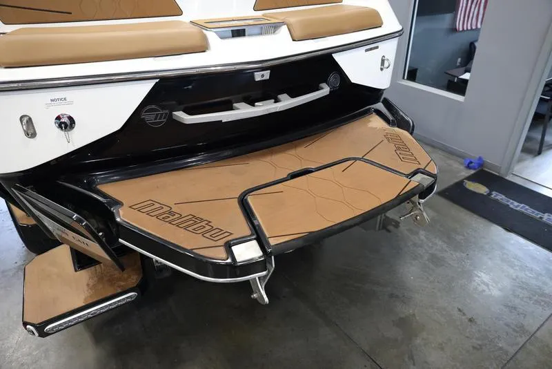 Slide: The Image of 2024 Malibu M220 boat rear view with swim platform and seating. - 6