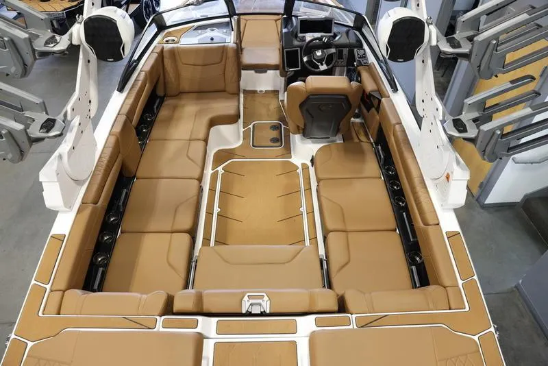 Slide: The Image of 2024 Malibu M220 boat interior with tan leather seating and modern dashboard. - 9