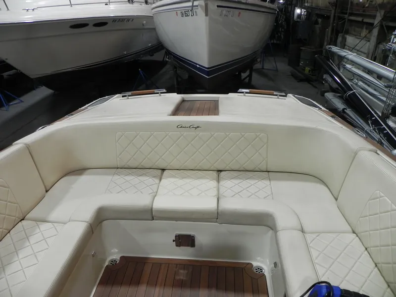 Slide: The Image of 2015 Chris-Craft 28 Heritage Corsair boat interior with cream seating and wood accents. - 19