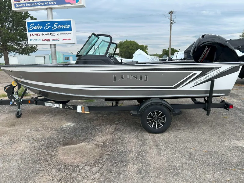 Slide: The Image of 2025 Lund 1875 Impact XS Fish boat on trailer at dealership. - 7