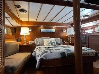 Slide: The Image of Luxurious cabin interior of 1984 Tayana 55 yacht with cozy bed and ambient lighting. - 10