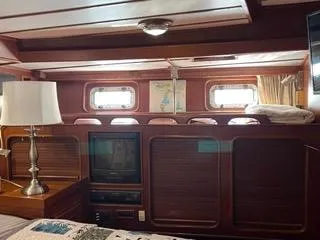 Slide: The Image of Interior of 1984 Tayana 55 yacht with wood paneling, TV, and lamp. - 11